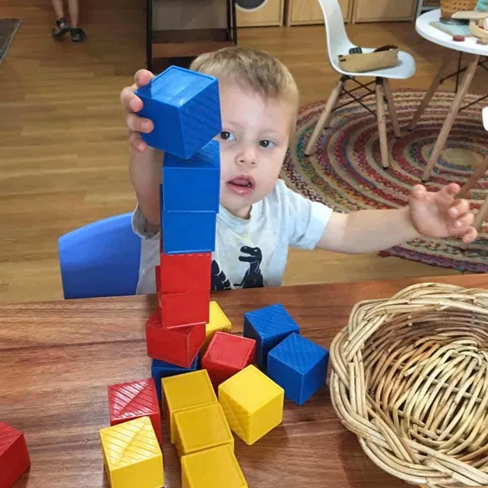 Toddler stacking coloured blocks